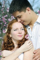 beautiful young couple in love among the flowering trees