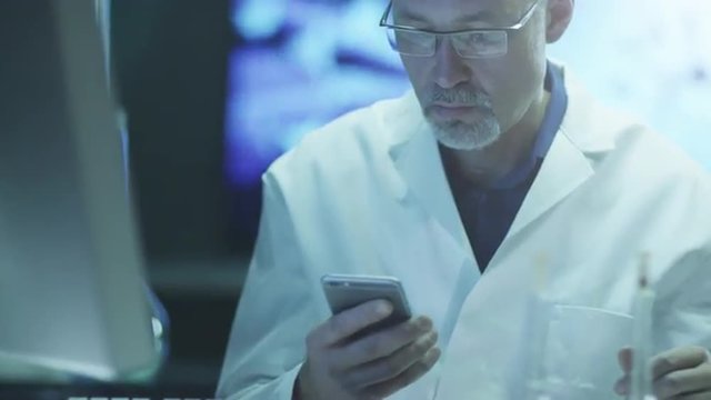 Scientist is Using Mobile Phone in Laboratory.

Shot on RED Cinema Camera in 4K (UHD).