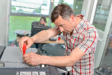 Man repairing photocopier
