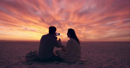 Happy romantic couple taking photograph of sunset using mobile phone camera wide shot on RED DRAGON - Powered by Adobe
