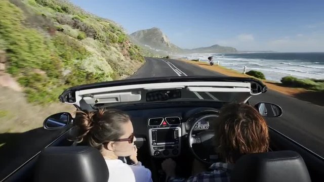 Couple driving convertible car cabriolet cape town south africa steadicam shot