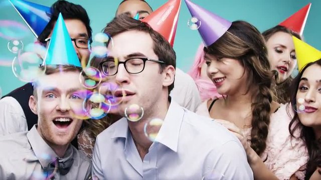 Multi racial group of happy people dancing with bubbles slow motion party photo booth 