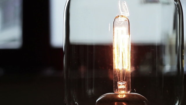 An old light bulb flashes on and of, close up