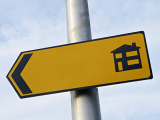 Blank sign on street light pointing in direction where to buy new houses