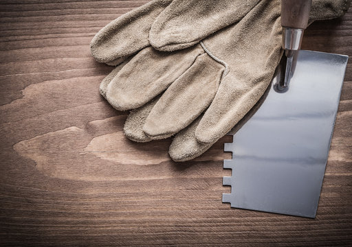 working gloves and putty spattle on wood board