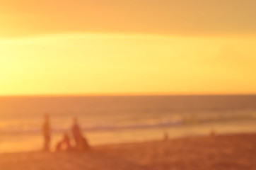 Naklejka na ściany i meble Blur people on sunset beach abstract background.