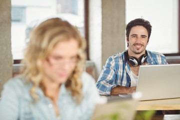 Portrait of smiling handsome business man using laptop in office