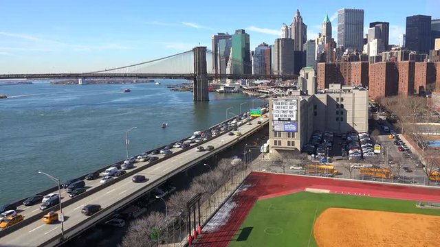 The Brooklyn Bridge, East River and FDR parkway on a clear sunny day in New York City.
