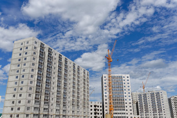 Fototapeta na wymiar Multi-storey houses and high-rise crane