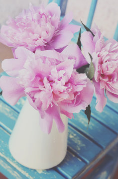 Bunch of peony on shabby blue chair, vintage effect