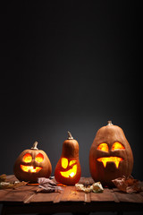 Obraz premium Jack o lanterns Halloween pumpkin face on wooden background