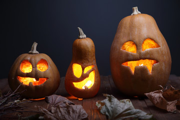 Jack o lanterns Halloween pumpkin face on wooden background