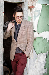 sexy fashion man model dressed vintage elegant holding a bag posing outdoor