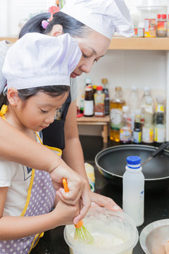 Little asian girl making pancake