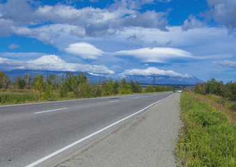 Clouds of the unusual form near volcanoes and road