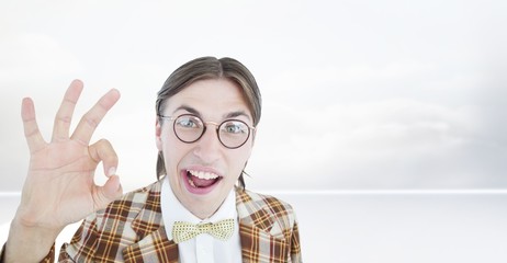 Composite image of geeky hipster doing the ok sign
