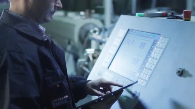 Factory Worker is Setting Up CNC Lathe Machine in Factory