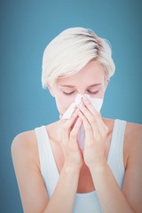 Composite image of sick woman blowing her nose