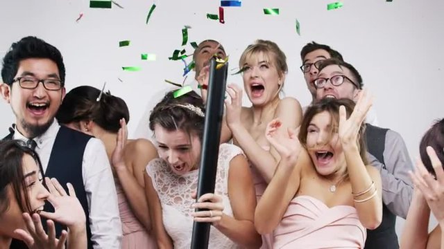 Multi ethnic group of people party poppers slow motion wedding photo booth series