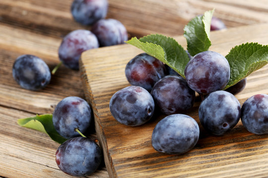 Fresh plums on brown wooden background