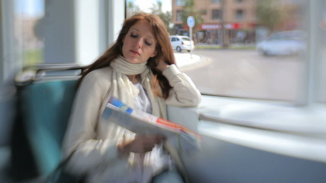 A young woman traveling in a tram.