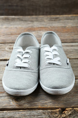 Pair of grey shoes on wooden background