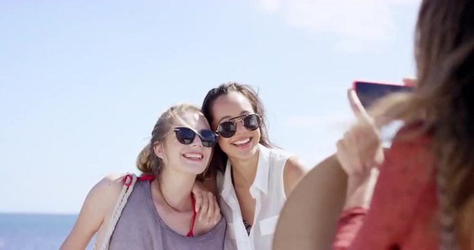 Group of Teenage girls taking photo using mobile phone at beach on summer vacation  close up