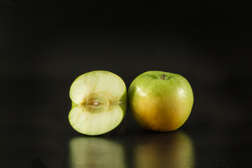 Green apple on the black background