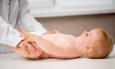 Obraz na płótnie Canvas doctor massaging baby`s legs