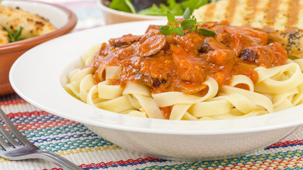 Szekely Gulyas - Hungarian goulash with pork sausage and sour cream on top of pasta and served with a slice of crusty bread.
