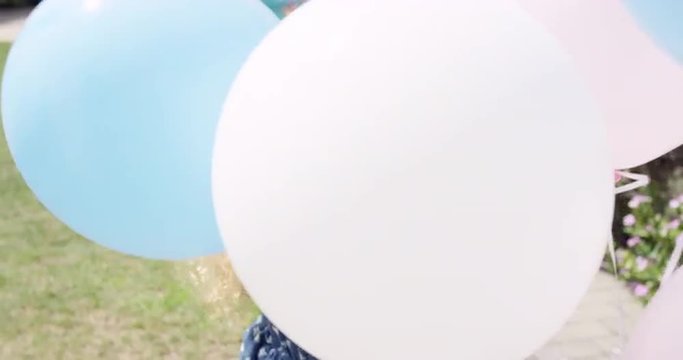 Little Blonde girl running with balloons in slow motion