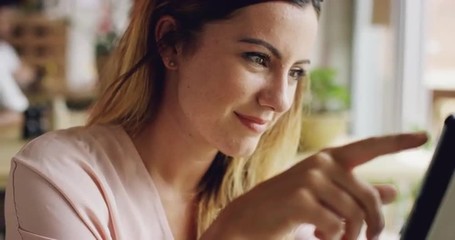 Beautiful woman using ipad tablet computer touchscreen in cafe - Powered by Adobe