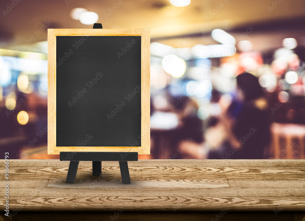 Poster blackboard menu with easel on wooden table with blur restaurant