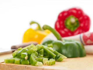 Red, yellow and green bell peppers on kitchen table