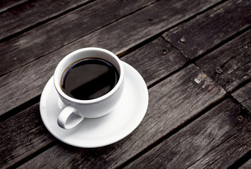 Hot black coffee with space on dark wooden floor