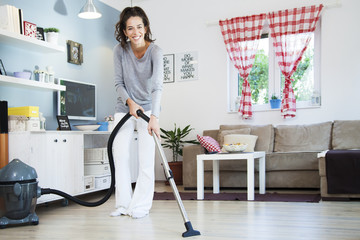 Woman with Vacuum Cleaner. Woman using vacuum cleaner at home in the living room