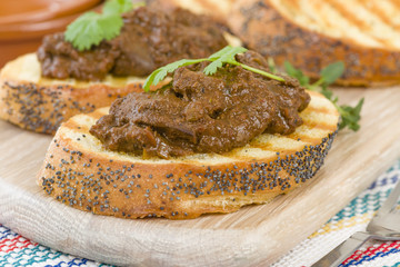 Higados de Pollo - Chicken livers with chorizo & spring onions finished with a dark Cajun tomato sauce on top of crusty bread.

