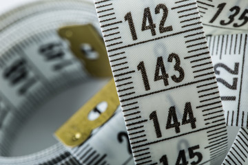 Curved measuring tape. Measuring tape of the tailor. Closeup view of white measuring tape