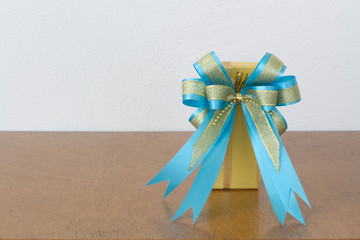 The big blue bow yellow gift box on the wood