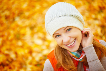 face of happy girl with autumn leaves on walk