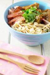 Chinese rice noodle roll with egg, chinese sausage, tofu (Kuay Teow Lod)  on blue bowl and white wood table