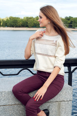 Tender young woman sitting on the pier