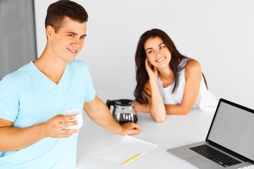 Couple having coffee near notebook. Focus on the man.