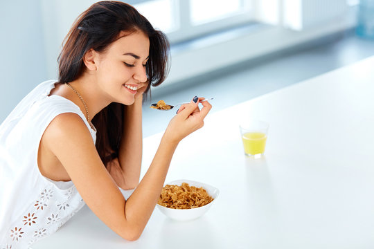 Woman with a spoon and a bowl of cereal looking down