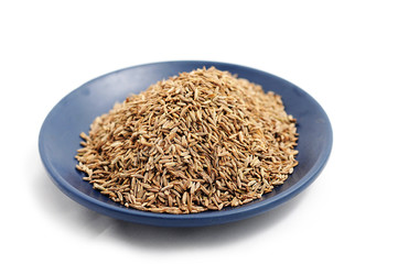 Macro cumin seeds on blue plate