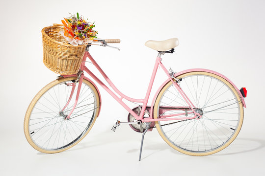 pink vintage bicycle whith flower basket isolated on white backg