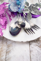 Christmas table setting in silver and blue tone on wooden table