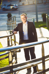 Handsome stylish businessman posing on stairs with railings