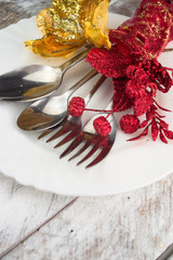Christmas table setting in gold and red tone on wooden table