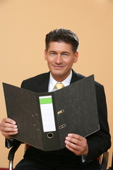 Mann im Anzug hält Aktenordner in den Händen